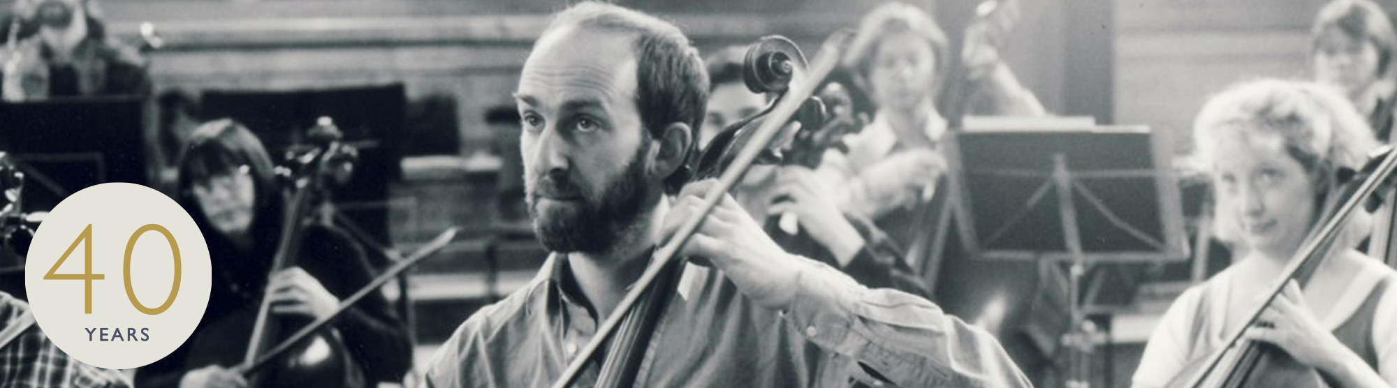 historical image of cellist in orchestra